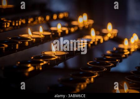 Rangées de bougies dans un support dans une cathédrale, avec une focalisation sélective Banque D'Images