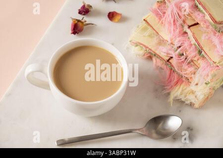 Savoureux petit déjeuner tendance avec café artisanal et chocolat rose avec remplissage aéré pismaniye blanc et rose sur panneau de marbre. Gros plan. Banque D'Images