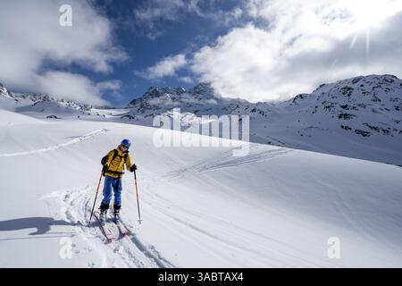 Randonneur de ski montant à travers un paysage de montagne pittoresque enneigé avec vue sur les sommets des montagnes, ascension au sommet de Kesch Pitschen, Buend Banque D'Images