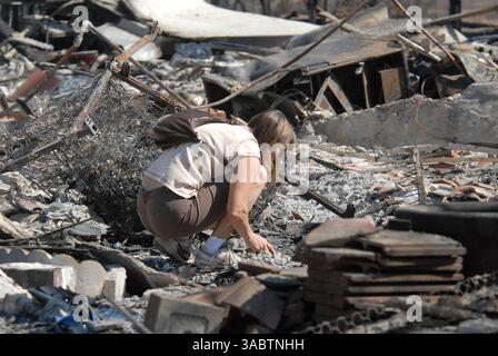 Oct 26, 2007 - San Diego, CA, États-Unis - NEDDY FONSECA fouille les décombres de sa belle-mère incendiée dans le quartier de Rancho Bernardo à San Diego. Les résidents ont entamé le processus de nettoyage et de rétablissement alors que les pompiers combattent encore cinq incendies majeurs dans le nord et l'est du comté. (Crédit image : © Earl S. Cryer/ZUMApress.com) Banque D'Images