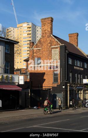 Piétons et cyclistes dans une rue de Londres, près du bâtiment Truman Hanbury Buxton & Co. La construction est en cours sur une tour voisine. Banque D'Images