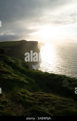 Vue imprenable sur les falaises de Moher, avec des falaises sur la gauche et l'océan Atlantique sur la droite. Banque D'Images