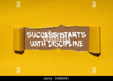 Le succès commence par un message de discipline écrit sur du papier jaune déchiré déchiré sur fond brun. Le succès conceptuel commence par le symbole de discipline. Copier Banque D'Images