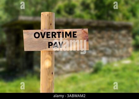 Message de paie d'heures supplémentaires écrit sur panneau en bois sur fond de nature. Symbole conceptuel de rémunération des heures supplémentaires. Copier l'espace. Banque D'Images
