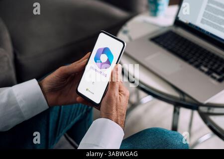 Homme utilisant un téléphone mobile affichant le logo de Microsoft Office 365 sur l'écran. ROSARIO, ARGENTINE - 2 AVRIL 2025. Banque D'Images