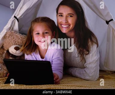 Tablette, tente et portrait de mère avec enfant à la maison en jouant à des jeux éducatifs ou des activités en ligne pour la liaison. Relax, couverture fort et maman avec Banque D'Images