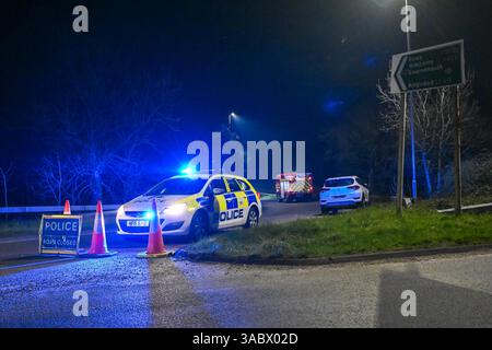 Poole, Dorset, Royaume-Uni. 3 avril 2025. Météo britannique. Un barrage routier de la police sur une bretelle d'accès à l'A350 vers le contournement d'Upton A35 où les pompiers stationnent avant de se diriger vers un énorme feu de forêt à Upton Heath à Poole dans le Dorset. De nombreux services d'urgence sont présents et le contournement A35 Upton fermé dans les deux sens en raison de la proximité de l'incendie. Ce dernier incendie dans la région de Bournemouth et Poole vient après une période de sécheresse prolongée avec des températures supérieures à la moyenne pour la période de l'année. Crédit photo : Graham Hunt/Alamy Live News Banque D'Images