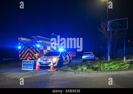 Poole, Dorset, Royaume-Uni. 3 avril 2025. Météo britannique. Un barrage routier de la police sur une bretelle d'accès à l'A350 vers le contournement d'Upton A35 où les pompiers stationnent avant de se diriger vers un énorme feu de forêt à Upton Heath à Poole dans le Dorset. De nombreux services d'urgence sont présents et le contournement A35 Upton fermé dans les deux sens en raison de la proximité de l'incendie. Ce dernier incendie dans la région de Bournemouth et Poole vient après une période de sécheresse prolongée avec des températures supérieures à la moyenne pour la période de l'année. Crédit photo : Graham Hunt/Alamy Live News Banque D'Images