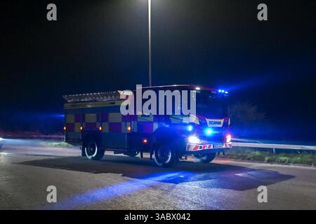 Poole, Dorset, Royaume-Uni. 3 avril 2025. Météo britannique. Un pompier se dirige vers la voie de contournement A35 Upton pour combattre un énorme feu de forêt à Upton Heath à Poole dans le Dorset. De nombreux services d'urgence sont présents et le contournement A35 Upton fermé dans les deux sens en raison de la proximité de l'incendie. Ce dernier incendie dans la région de Bournemouth et Poole vient après une période de sécheresse prolongée avec des températures supérieures à la moyenne pour la période de l'année. Crédit photo : Graham Hunt/Alamy Live News Banque D'Images