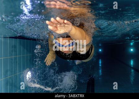 athlète féminine nageant dans une piscine, photo sous-marine. Banque D'Images