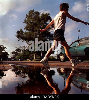 (Publié le 24/01/2003, section spéciale, Super Bowl-20) Un marcheur de puissance s'éloigne d'une flaque réfléchissante juste à l'ouest du pont Cabrillo dans le parc Balboa mardi matin. UT/John Gastaldo Banque D'Images