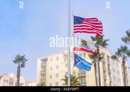 Oceanside, Californie - 3 janvier 2025 : affichage vibrant des drapeaux américain et californien en Berne, face à un ciel brumeux à Oceanside, Cali Banque D'Images