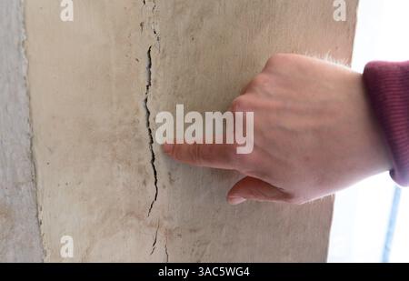 PRODUCTION - 01 avril 2025, basse-Saxe, Lüneburg : Frieder Küpker, du département de gestion des bâtiments de la ville, signale des fissures dans la façade de la mairie. De petites fissures dissimulent des dégâts majeurs - la façade historique de l'hôtel de ville de Lüneburg deviendra un chantier de construction au cours des deux prochaines années. Photo : Philipp Schulze/dpa Banque D'Images