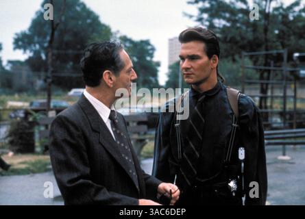 DATE DE SORTIE : 20 octobre 1989. TITRE DU FILM : Next of Kin. STUDIO : Lorimar film Entertainment. INTRIGUE : Truman, un flic de Chicago, cherche le tueur de son frère. Pendant ce temps, un autre de ses frères, Briar (un hillbilly) décide de trouver le tueur lui-même. SUR LA PHOTO : PATRICK SWAYZE dans le rôle de Truman Gates. Banque D'Images