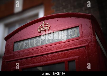 Cabine téléphonique rouge britannique emblématique avec emblème de la couronne dorée, située à l'extérieur du bâtiment du bureau de poste de Rochester, à Medway, Kent Banque D'Images