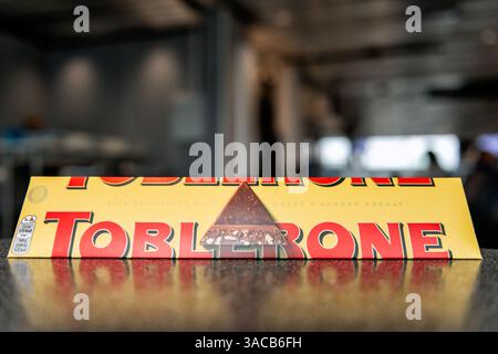 Francfort, Allemagne - 28 août 2023 : Toblerone énorme barre de chocolat au lait sur la table avec l'aéroport en arrière-plan flou Banque D'Images