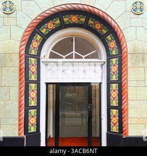Une entrée voûtée colorée encadrée de carreaux émaillés floraux et de finitions audacieuses en terre cuite met en valeur la façade du bâtiment historique de Chicago. Banque D'Images