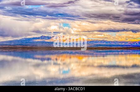 Salar de Uyuni, Bolivie. Vue de paysage grand angle des nuages de tempête reflétés sur le Salar de Uyuni, avec les montagnes des Andes au loin. Banque D'Images