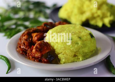 Tapioca bouilli et purée servi avec un curry de poulet riche et épicé, infusé d'épices aromatiques. Capturé sous un angle pour accentuer la texture et la couleur. Banque D'Images
