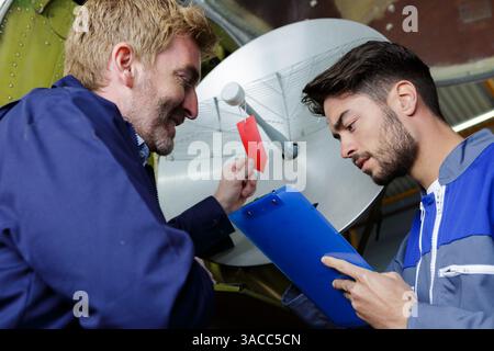 techniciens vérifiant ou installant un téléviseur parabolique Banque D'Images