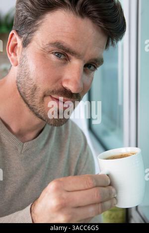 beau gars tenant une tasse de café Banque D'Images