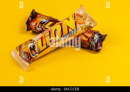Lviv Ukraine 04.02.25 deux barres de chocolat Lion White sont habilement disposées sur une surface jaune vif, mettant en valeur leur emballage et leur design attrayant t Banque D'Images