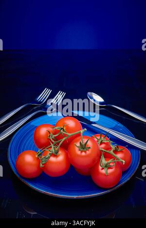 Tomates, vigne mûrie sur assiette Banque D'Images
