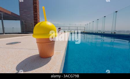Tasse de crème glacée près de la piscine un jour d'été Banque D'Images