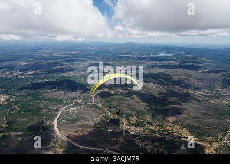 Vue aérienne d'un parapente volant une aile ozone jaune au-dessus de Pena Lobo et des éoliennes. Banque D'Images