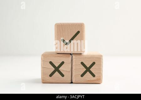 Approuver ou rejeter. Cubes en bois avec des marques de contrôle et de croix sur fond blanc Banque D'Images