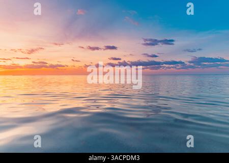 Coucher de soleil éclatant paysage marin horizon nuages de ciel colorés, vagues douces inspirant la surface de l'eau relaxante et les reflets. Papier peint océan méditation Banque D'Images