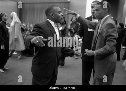 16 mars 2004 ; Cleveland, Ohio, États-Unis ; (photo du dossier) à toute réunion donnée, deux membres du fruit de l'Islam sont assignés pour passer en revue chaque nouvelle arrivée, et ils le font avec une franchise qui ravirait un sergent de police. Les poches doivent être tournées à l'envers ; les revers des manteaux, les cols et les poignets des pantalons sont tous pris en compte. Les jambes du pantalon doivent être relevées pour montrer que rien n'est dissimulé dans les chaussettes. Pendant que les bras du visiteur sont tenus en hauteur, un foi place ses mains écartées de chaque côté du cou et en un balayage continu les traîne soigneusement le long des côtés du corps jusqu'aux chevilles. L'ARMP Banque D'Images