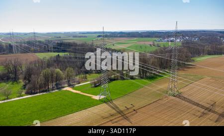 Günzburg, Bavière, Allemagne - 4 avril 2025 : deux pylônes à haute tension massifs relient des régions et permettent la circulation de l'énergie sur de longues distances. Un symbole de réseaux électriques fiables et d'infrastructure technologique. *** Zwei massive Hochspannungsmasten verbinden Regionen miteinander und ermöglichen den Fluss von Energie über weite Distanzen. Ein Symbol für verlässliche Stromnetze und technologische Infrastruktur. Banque D'Images