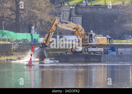Des travaux de démolition sont en préparation à la suite de l'effondrement de certaines parties du pont Carola. Une excavatrice verse des pierres de rivière d'un ponton dans l'Elbe Banque D'Images