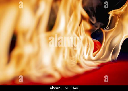 Une table de billard est engloutie dans les flammes, avec des boules flamboyantes dispersées à travers le feutre rouge carbonisé. La fumée se courbe vers le haut, projetant des ombres étranges, comme chacun Banque D'Images