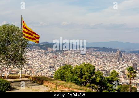 Drapeau catalan flotte au-dessus de l'ancienne forteresse militaire du château de Montjuic sur la montagne de Montjuic surplombant la ville, Barcelone, Espagne. Banque D'Images