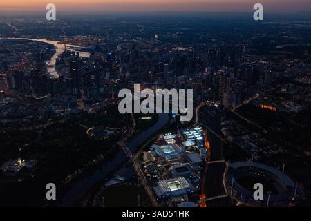 Vue aérienne du quartier du parc olympique illuminé au crépuscule avec pour toile de fond les lumières de la ville de Melbourne lors de l'Open d'Australie du Grand Chelem. Banque D'Images