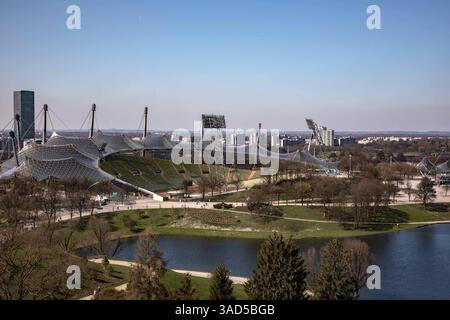 München, Deutschland 03. Avril 2025 : Im Bild : Blick vom Olympiaberg auf den Stadtpark mit Olympiastadion und See, im Hintergrund der O2-Tower. Bayern *** Munich, Allemagne 03 avril 2025 dans la vue de l'Olympiaberg au parc de la ville avec le stade olympique et le lac, en arrière-plan la Tour O2 Bavière Copyright : xFotostandx/xFritschx Banque D'Images