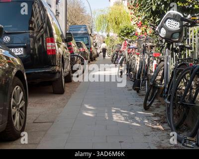 Konfliktzone Gehweg Fußgänger zwischen parkenden Autos und abgestellten Fahrrädern 20250405ad026 aufgesetztes Parken Gehweg Bürgersteig Hamburg Eimsbüttel Hoheluft West Generalsviertel Kottwitzstraße Abstellfläche, Alltag, Auto, Autos, Autoverkehr, Bewegung, Bordstein, Bürgersteig, ville, Fahrrad, Fahrräder, Fahrradständer, Fahrradverkehr, Fußgänger, Gehweg, Innenstadt, Parkplatz, passant, Platzmangel, Privatauto, Raumkonflikt, Ruhezone, Sicherheit, Stadt, Stadtraum, Straße, Straßenverkehr, Umwelt, Nutzung, Verkehrsraum, Wohngebiet, Zweirad abwechslungsreich, alltagsnah, begrenzt, belegt, beleb Banque D'Images