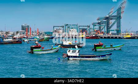 Port très fréquenté avec bateaux de pêche et grues industrielles Banque D'Images