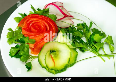 Des garnitures magnifiquement arrangées de tomates tranchées, de concombres, de radis et d'herbes fraîches sont présentées sur une assiette blanche. Cet affichage vibrant de végéta Banque D'Images