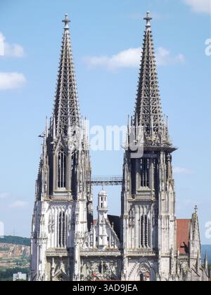Une vue rapprochée d'une cathédrale historique avec deux grandes flèches ornées avec des détails architecturaux complexes sur un ciel bleu avec des nuages dispersés Banque D'Images