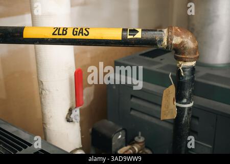 Tuyau de gaz au chauffage au gaz naturel dans la chaufferie du bâtiment. Gros plan de la conduite de gaz de 2 lb. Flèche indiquant la direction de la chaudière. Gaz sûr, technicien ou plumbi Banque D'Images