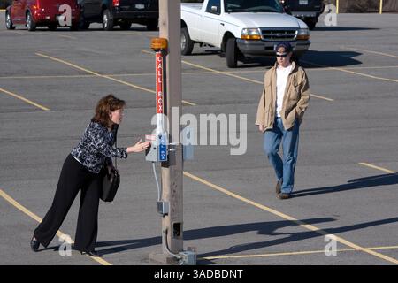 Apr 10, 2008 - Dallas, Texas, États-Unis - femme d'affaires solitaire sur le chemin de sa voiture dans un parking déserté cherche la sécurité de la boîte d'appel de sécurité avec un homme suspect dans le lot (image de crédit : Ed Lallo/ZUMAPRESS.com) Banque D'Images
