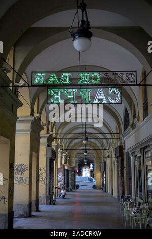 Turin, Italie - 08 novembre 2021 : des enseignes lumineuses au néon vert pour « CAFFE » et « SNACK BAR » sont suspendues sous le plafond voûté d'une passerelle couverte bordée de cl Banque D'Images