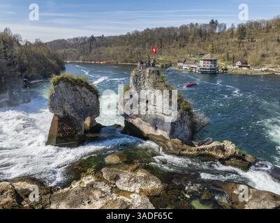 Vue aérienne des chutes du Rhin à basse eau au printemps, avec des touristes sur la plate-forme d'observation, à droite le restaurant panoramique Schloessli Woerth, Banque D'Images