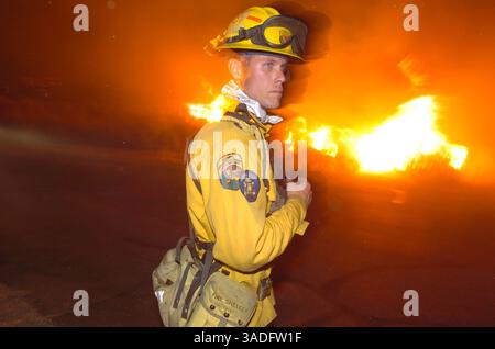 11 juillet 2004 ; Palm Springs, CA, États-Unis ; BRANDEN SMITH, pompier du comté de Riverside, garde un œil sur l'incendie de Verbenia alors qu'il s'abat sur la ville de Snow Creek près de Palm Springs. Plus de 600 acres ont été brûlés. Les vents extrêmes, les températures dans les années 100 et le faible taux d'humidité maintiennent la petite communauté de Snow Creek en alerte. . (Crédit image : Steven K. Doi/ZUMAPRESS.com) Banque D'Images