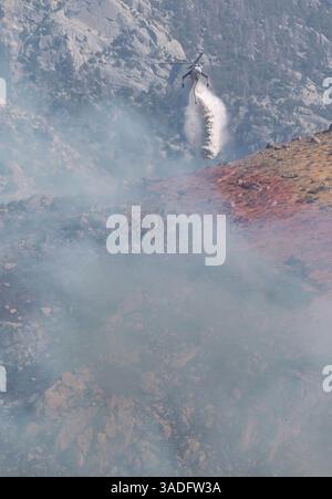 11 juillet 2004 ; Palm Springs, CA, États-Unis ; de l'eau tombe au sommet des montagnes près de la région sauvage de San Jacinto alors qu'un feu de broussailles brûle hors de contrôle près de Palm Springs plus de 600 acres ont été brûlés. Les vents extrêmes, les températures dans les années 100, et le faible taux d'humidité, maintiennent la petite communauté de Snow Creek en alerte. (Crédit image : Steven K. Doi/ZUMAPRESS.com) Banque D'Images