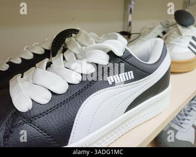 Aktau, Kazakhstan - 22 mars 2025 : baskets puma noir et blanc exposées dans un magasin de chaussures. Banque D'Images