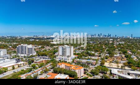Vue aérienne des quartiers de Coral Gables avec l'horizon de Miami s'élevant au loin par une journée ensoleillée claire. Banque D'Images